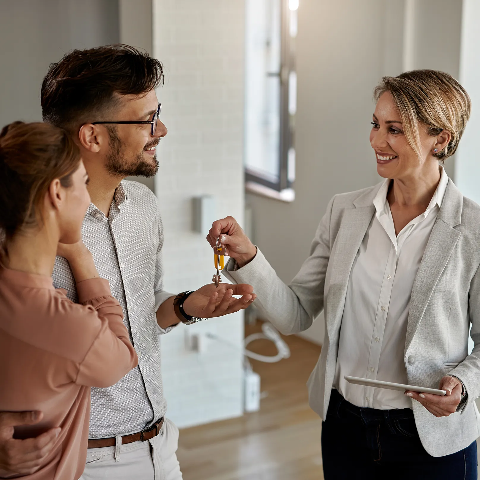 Property manager handing keys to a new resident, symbolizing automated user onboarding.