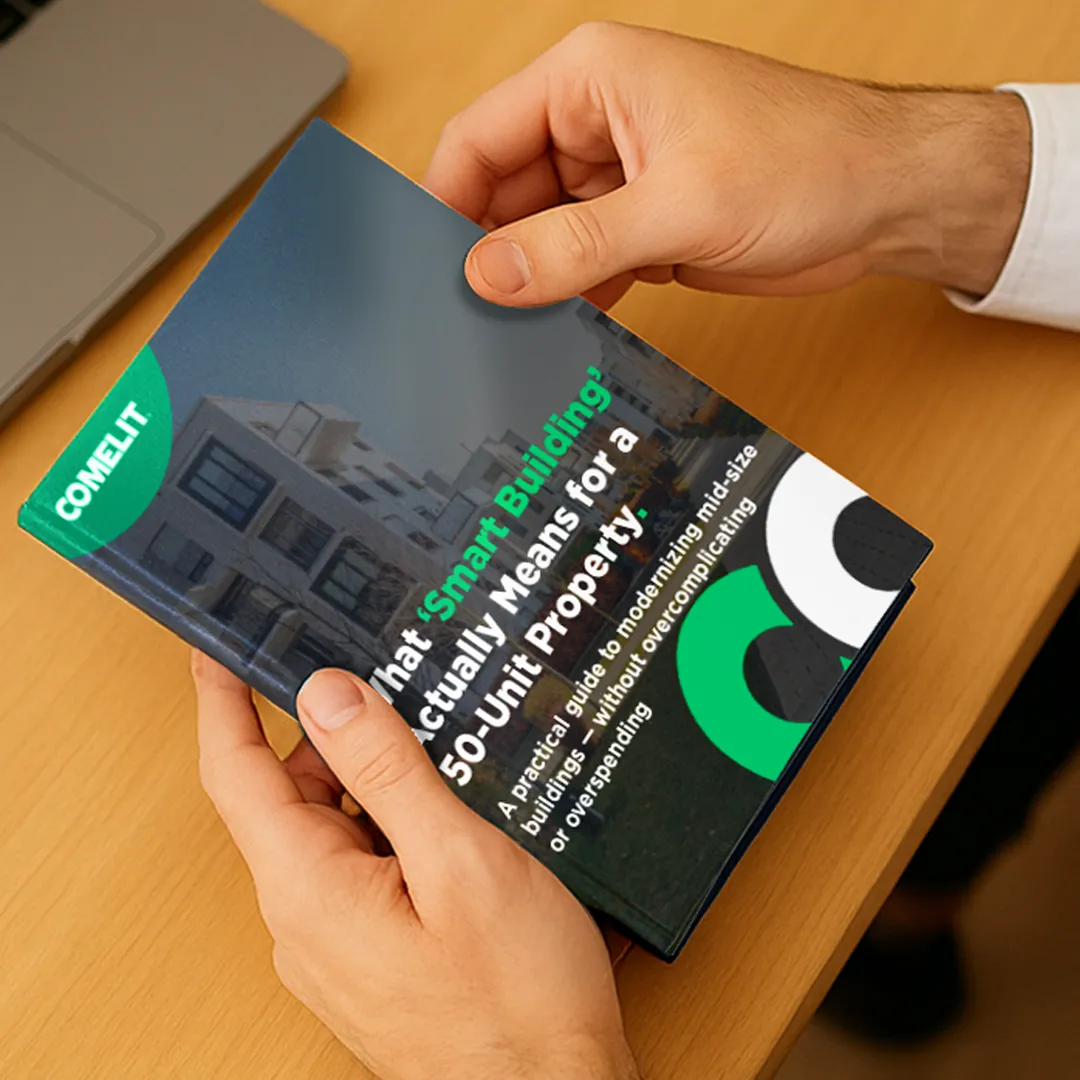 Property manager holding the Comelit Smart Building Guide for a 50-unit property